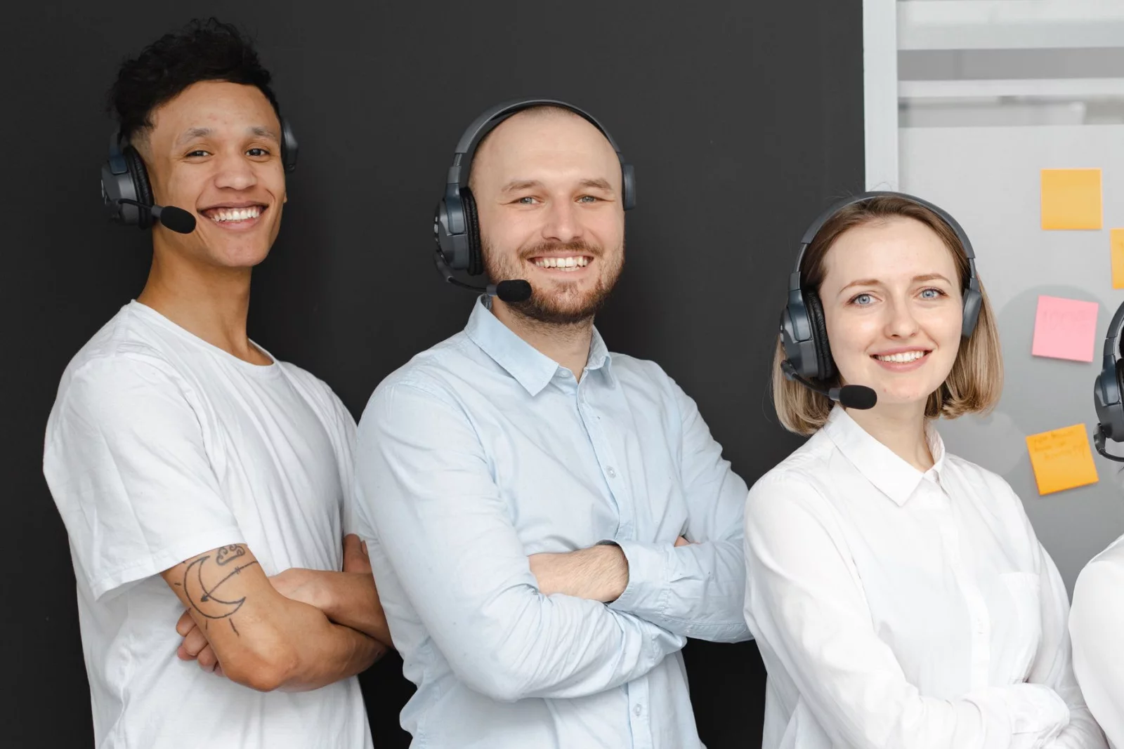Équipe de téléconseillers souriants, casques-micros sur la tête