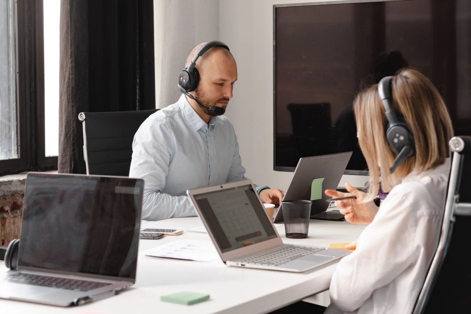 Téléopérateurs au casque au travail sur un plateau lumineux