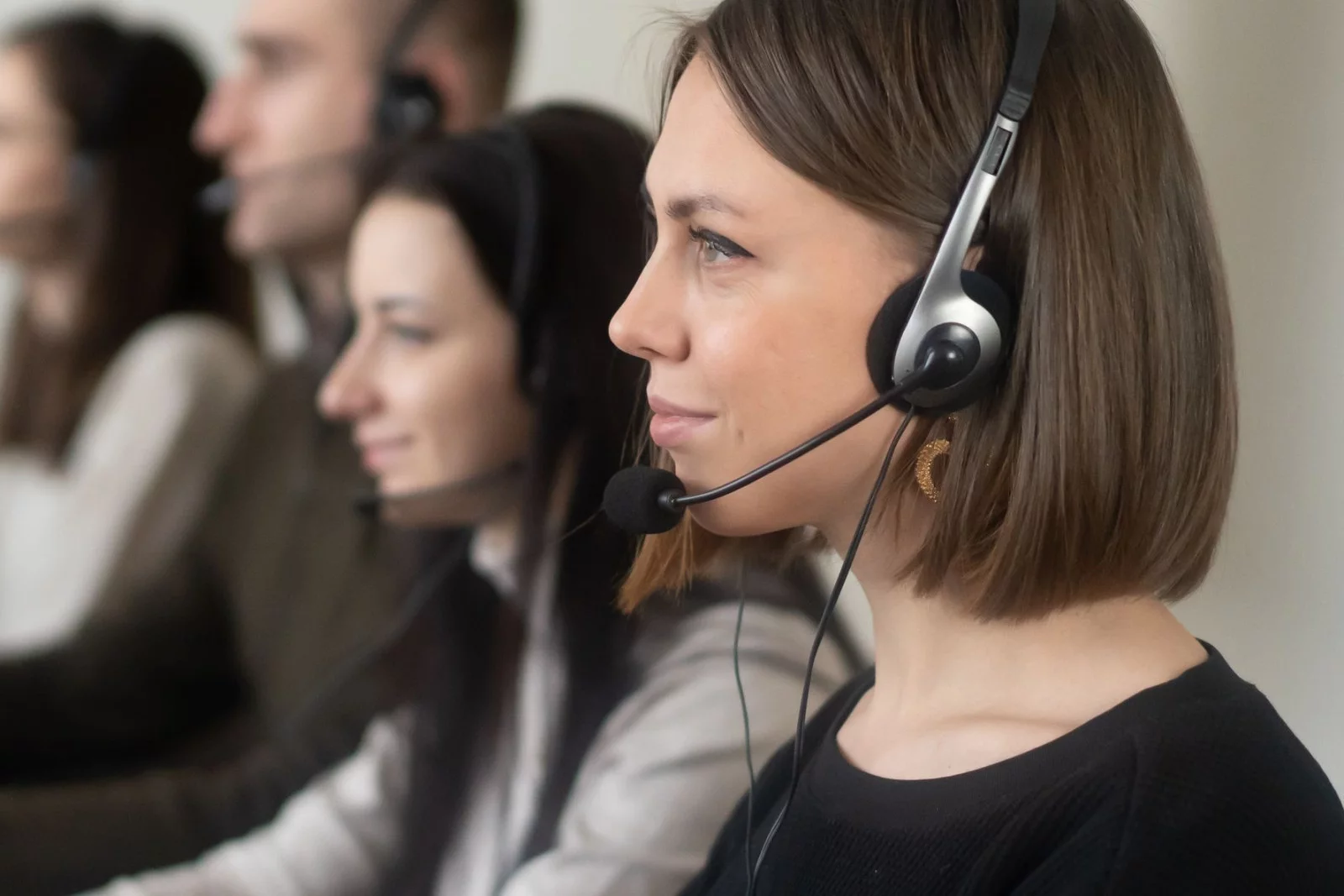 Équipe de téléopérateurs au casque alignés devant leurs postes